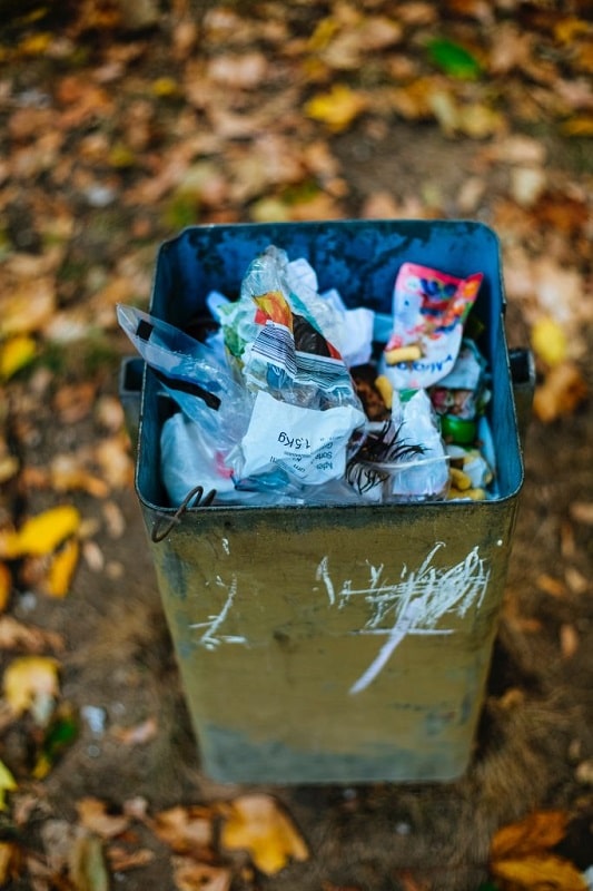 Closed-up of a trash can with plastic trashes placed inside.